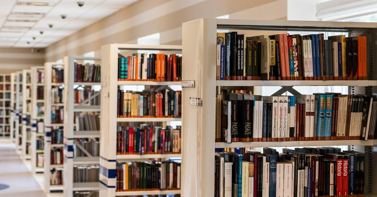 rader av bokhyllor med böcker i ett bibliotek